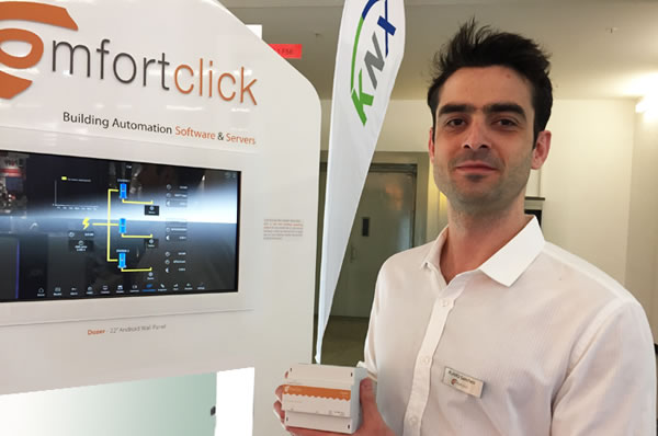 ComfortClick's Flavio Sanches demonstrating ComfortClick software on the new ComfortClick Dozer Android 22" wall panel, and holding the ComfortClick Jigsaw KNX server that includes a ComfortClick bOS Pro licence.
