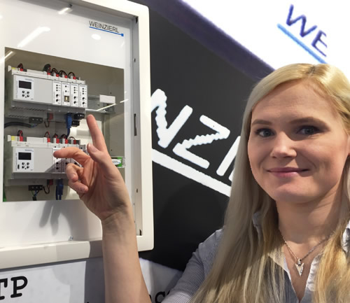 Weinzierl's Head of Test Laboratory, Elena Eckbauer, pointing out the KNX IO 511 secure switching actuator alongside the Weinzierl KNX Multi IO 570 universal input and output module that supports 48 digital channels.